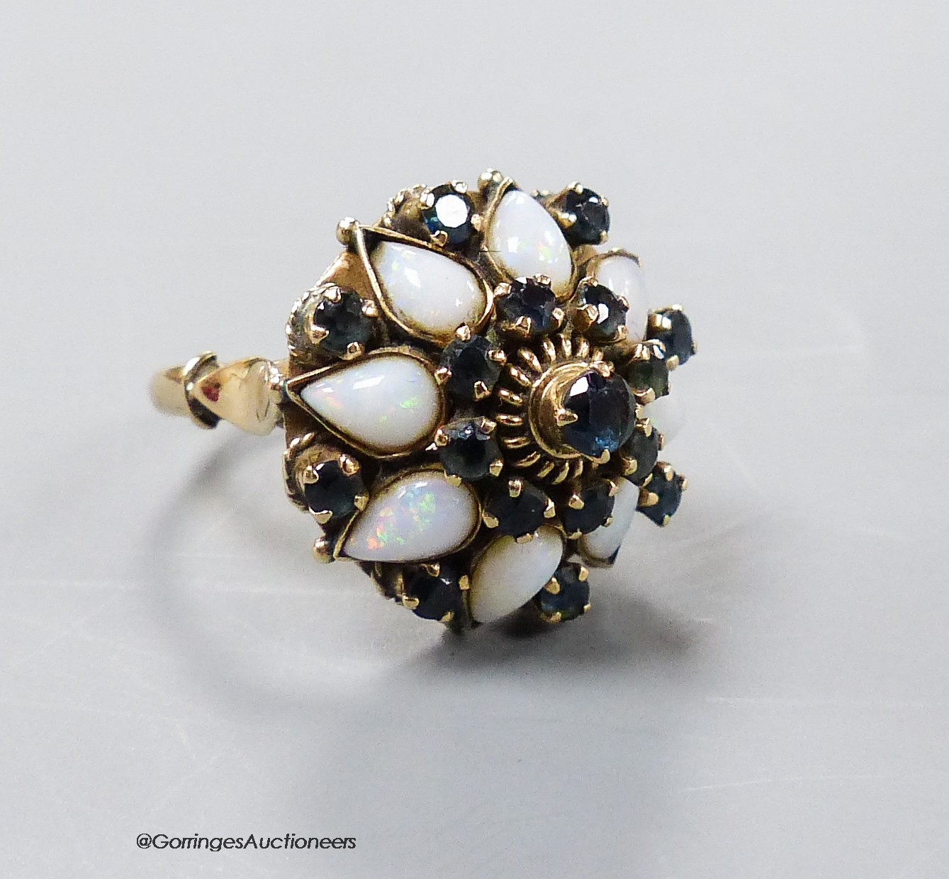 A yellow metal (stamped 18k), white opal and sapphire cluster set 'hareem' ring, size O, gross 6.6 grams.